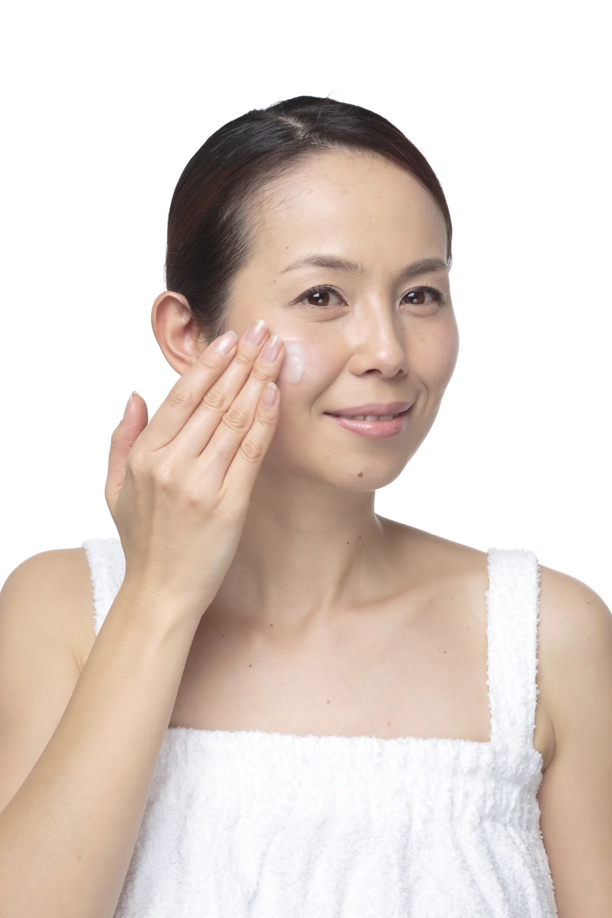 頬へモイスチャークリームをなじませる女性